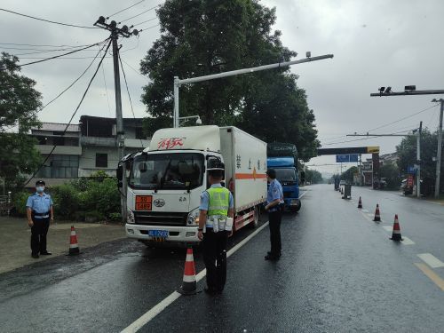 公安民警冒雨在萬載縣鐵山界省際查緝點檢查過往車輛
